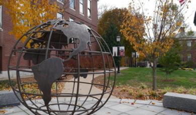 Globe sculpture in front of Boyden Hall with U.S. flag